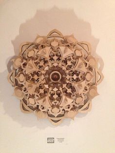 an intricately designed wooden object on display in a museum exhibit space with white walls