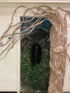 an art piece is displayed in front of a door decorated with paper mache and branches