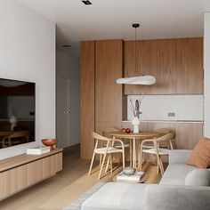 a living room filled with furniture and a flat screen tv mounted on a wall above a wooden table