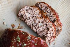 two slices of meatloaf sitting on top of a paper plate