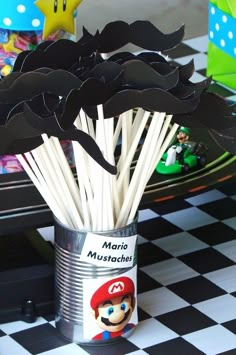 there is a tin can that has some sticks in it and mario on the side