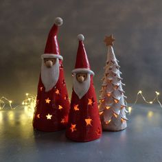 three small christmas trees with santa hats on them and lights in the shape of stars