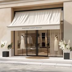 the shopfront of a fashion store with white dresses on display