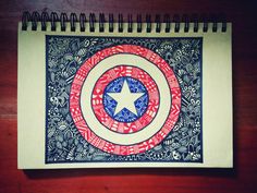 a spiral notebook with an image of the captain's shield in red, white and blue