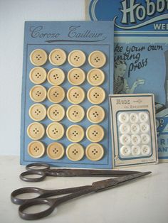 a pair of scissors and buttons sitting on top of a table