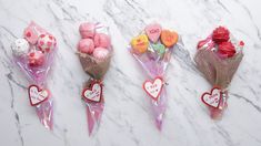 three bags filled with candy sitting on top of a marble counter next to each other