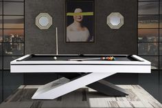 a pool table with two billards in front of a painting on the wall behind it