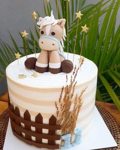 a birthday cake with a horse sitting on it's side and stars around the top