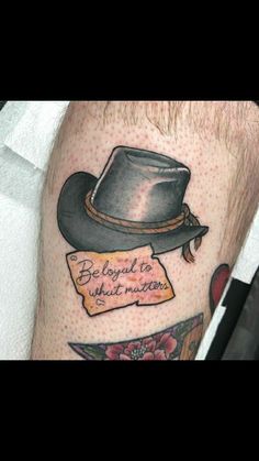 a man's leg with a hat on top of it and an inscription below