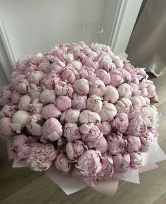 a bouquet of pink flowers sitting on top of a wooden floor next to a door