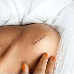 a woman's back with the word love written on her left side, in cursive font