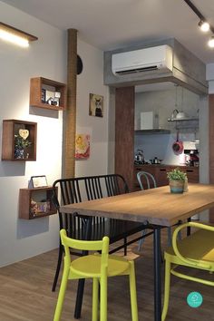 a dining room table with yellow chairs and an air conditioner in the back ground