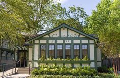 a small building with green trim and windows