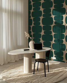 a white table with a laptop on it in front of a green and white wall