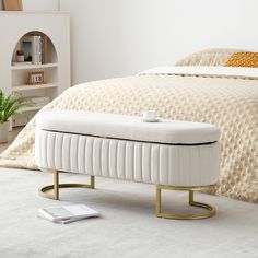 a white bed sitting next to a book shelf on top of a carpeted floor