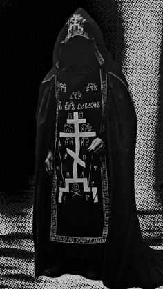 a black and white photo of a person wearing a robe with writing on the back