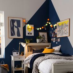 a bedroom decorated in blue and yellow with pictures on the wall