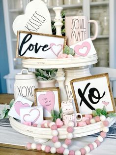 a table topped with two tiered trays filled with valentine's day decorations