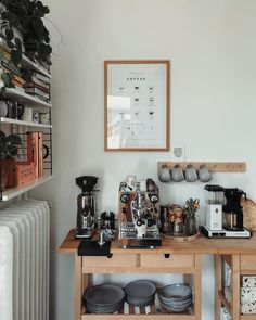 a coffee bar with pots and pans sitting on it's table next to a radiator