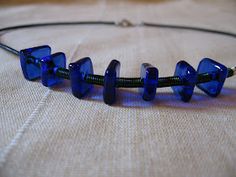 a blue glass beaded necklace sitting on top of a table