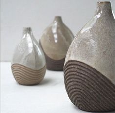 three ceramic vases sitting next to each other on a table