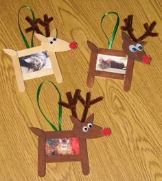 three reindeer ornament hanging on a wooden table with cat and dog pictures in them