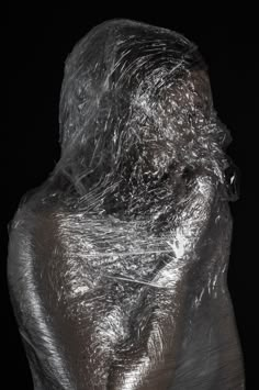 a black and white photo of a person wrapped in plastic