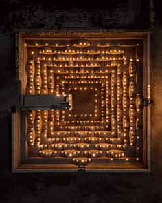 an overhead view of candles in a wooden box with lights on the inside and around it