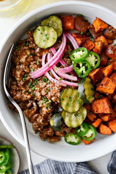 a white bowl filled with meat and vegetables