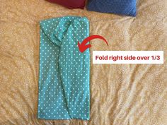 the bed is covered with blue and white polka dot sheets, which have been folded over