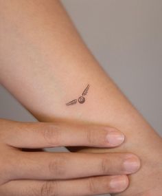 a woman's left arm with a small tattoo on the wrist and an arrow