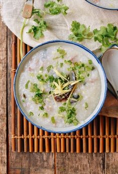 two bowls filled with rice and garnished with cilantro on a bamboo mat