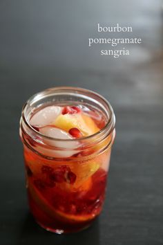 a jar filled with liquid and fruit on top of a table