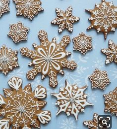 some very pretty decorated cookies on a blue tablecloth with snowflakes in the background