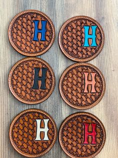 four leather coasters with the letter h on them