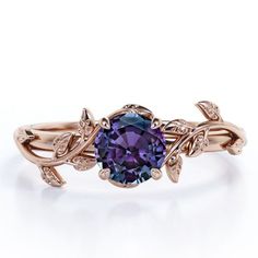 a ring with an oval purple stone surrounded by leaves on the band and two diamonds