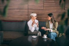 two women sitting on a couch talking to each other