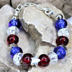 Fabulously patriotic bracelet feature Red White and Blue Beads and Star beads. Nothing says I love America with more style! ❤️COLORS: Silver Bracelet with Tibetan Silver Star and Blue Red and White glass beads. ❤️SIZE: The bracelet is approximately 1/2 inch wide and comes with a 1 1/2 inch extension chain to comfortably fit size 6 1/2 to 8. ❤️MATERIALS: This bracelet is made of silver plated copper, the beads are Tibetan Silver, blue red and white glass beads. All materials are nickel and lead f Bead Star Bracelet, Bead Star, Star Beads, Lovers Necklace, Patriotic Stars, Wire Wrapped Bracelet, Usa Patriotic, Dog Jewelry