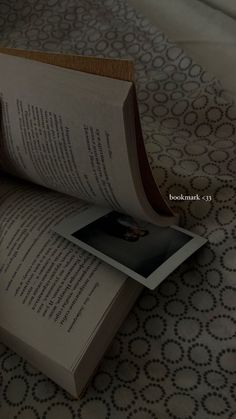 an open book sitting on top of a bed