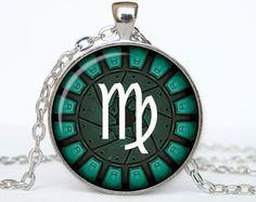 the zodiac sign is depicted on a green background in this glass dome pendant with chain