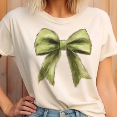 Add a playful twist to your holiday wardrobe with the Grinch Bow Christmas Tee! This festive tee features a sublimation print of the iconic Grinch, complete with a cheerful bow, blending a touch of mischievous fun with holiday spirit. Made from a soft and cozy 50/50 poly-cotton blend, it’s perfect for spreading holiday cheer while staying comfortable. Easy to care for with machine washable fabric. Whether you're a fan of the classic story or just love adding a quirky touch to your Christmas outf Grinch Bow, Scarf Coverup, Rebecca Black, Grinch Shirts, Bow Christmas, Holiday Wardrobe, The Grinch, Blazer With Jeans, Christmas T Shirt