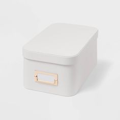 a white storage box with gold handles on the lid and bottom, sitting against a white background