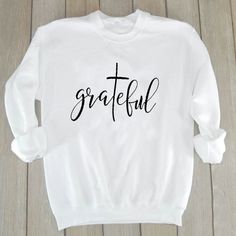 Grateful Christian Sweatshirt | Wear this Sweater with pride knowing that a % of your purchase goes towards spreading the word of God. Part will go to building new churches, and part will go to sending missionaries around the world. Our Grateful Christian Sweatshirt is not only adorable but extremely soft too! Its bold Message will be sure to turn heads! #christianapparel #womensfashion #winteroutfits #winterfashion #sweateroutfits #winteroutfits #sweater #womenssweater #valerymilano Love Slogan, Letter Sweatshirt, Women Of Faith, Thankful And Blessed, Hoodie Outfit, Christian Clothing, Casual Pullover