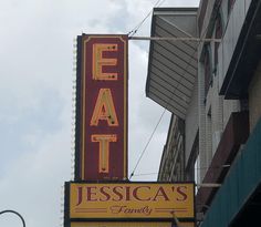 a restaurant sign hanging off the side of a building