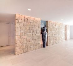 a large black vase sitting in the middle of a room next to a stone wall