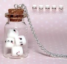 a glass jar filled with white dices sitting on top of a table next to a chain