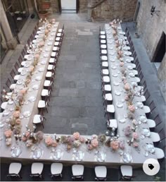 an overhead view of a long table set up with white and pink flowers on it