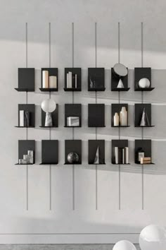 several black and white shelves on the wall with books, vases and other items