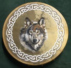 a painting of a wolf on a gold and white plate with chains around it's neck