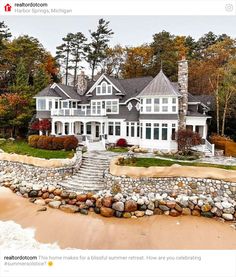 this is an aerial view of a large house on the shore with stairs leading up to it